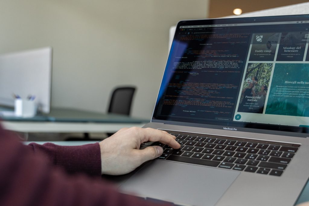 Un individuo sta lavorando su un laptop con una pagina web visibile
