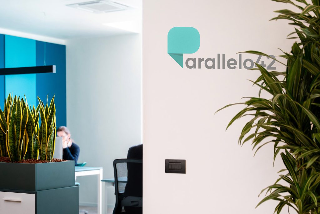 Interno dell'ufficio di Parallelo42, caratterizzato da arredi minimalisti e un ambiente collaborativo